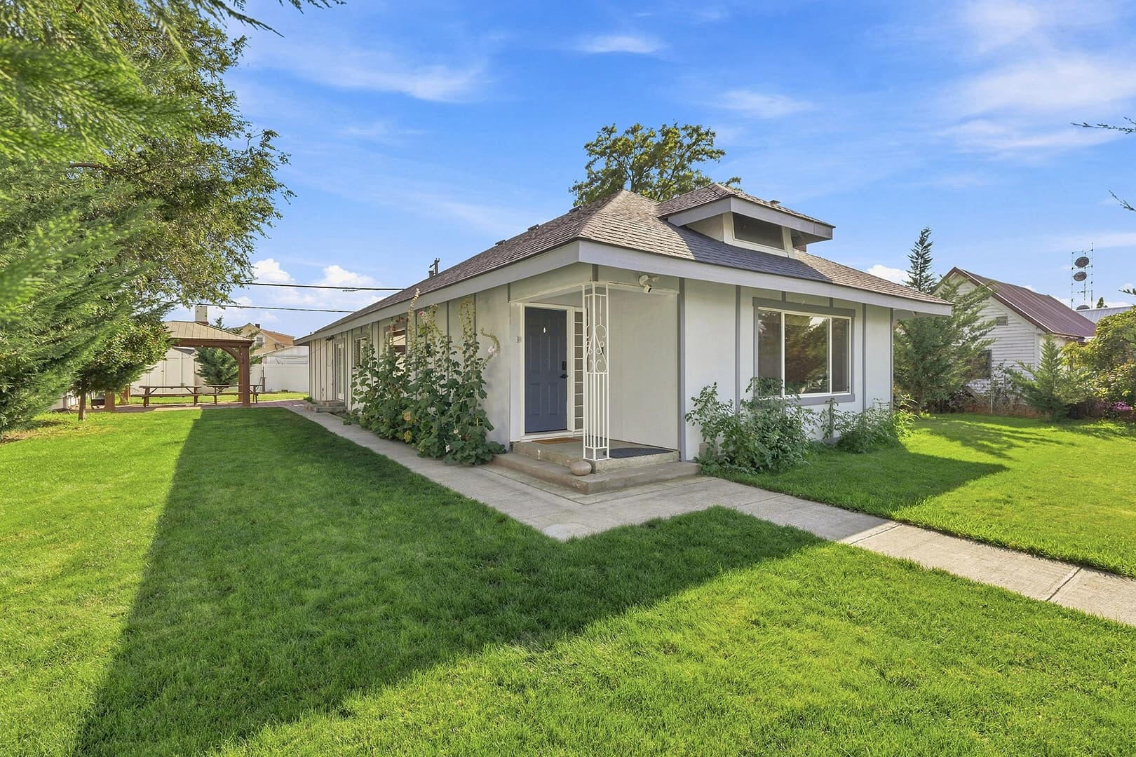 Sun Lake Retreat vacation rental in Coulee City, with a covered front porch, green lawn and walkway.