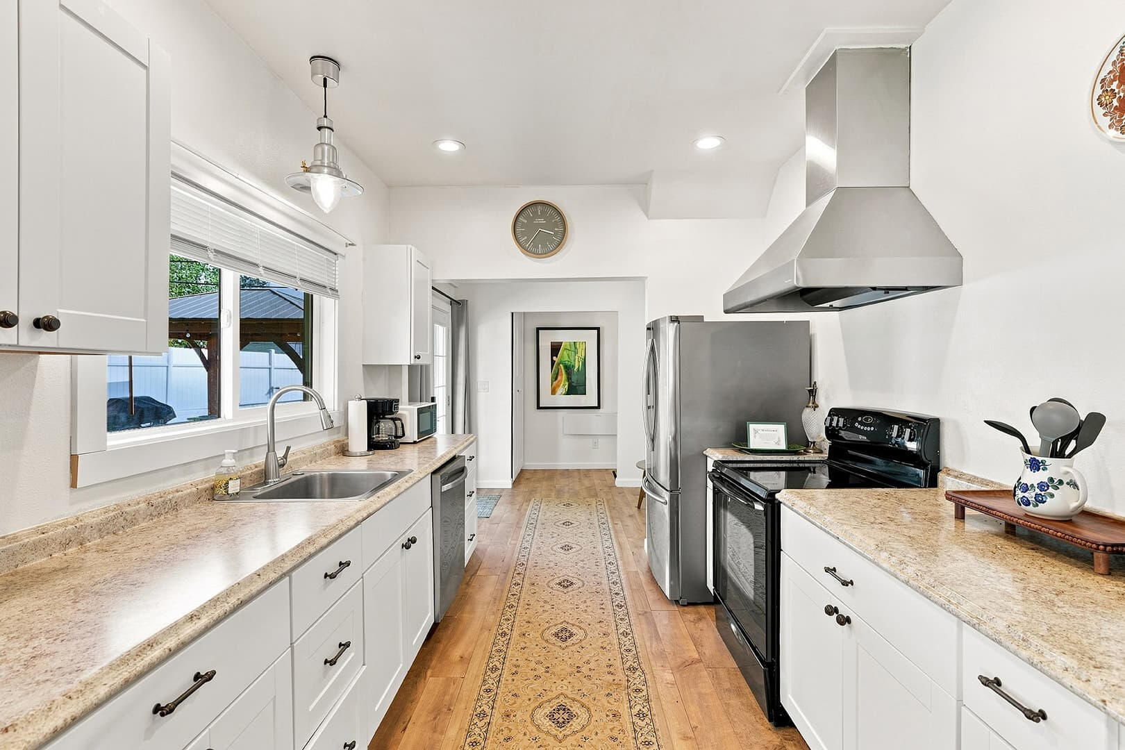 Kitchen with white cabinets, long countertops, a refrigerator and stove at Sun Lake Retreat.